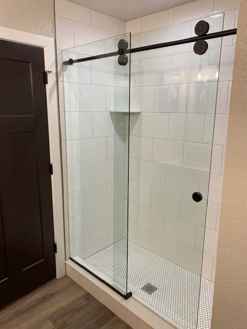 Walk-in shower with frameless glass and tiled walls
