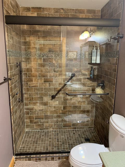 Sliding glass shower doors on white base during bathroom renovation