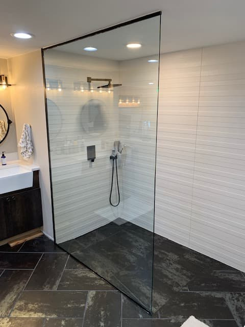 Frameless shower door with textured privacy glass and chrome hardware